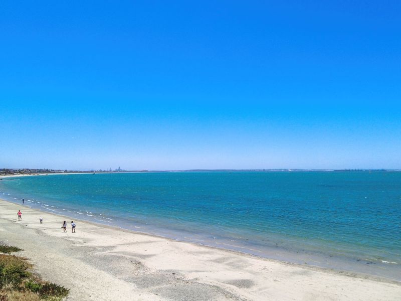 A scenic coastal view overlooking the sandy beach and ocean, highlighting the property's prime location and natural surroundings.