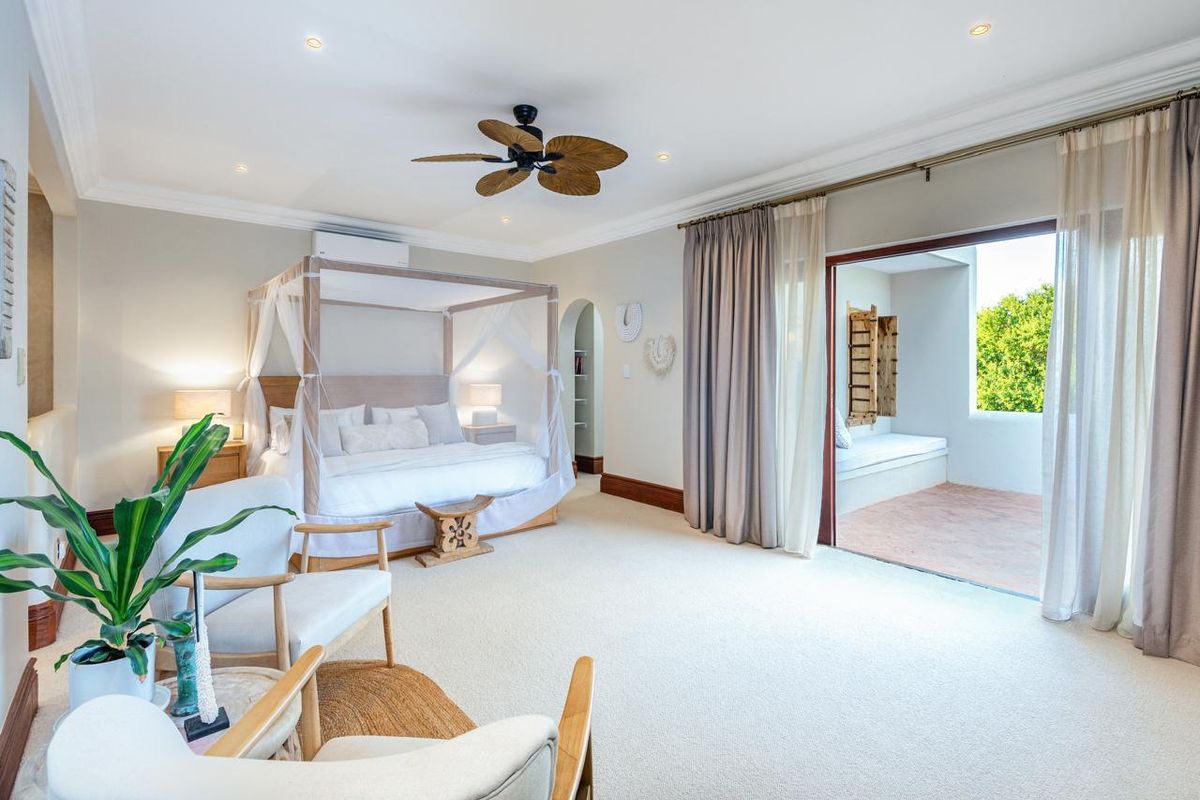 Spacious bedroom featuring neutral carpeting, recessed lighting, a ceiling fan, and direct access to a private balcony through sliding glass doors.