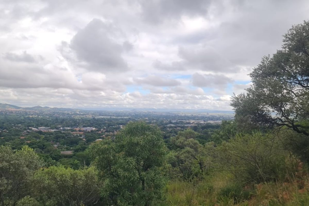 A scenic elevated view overlooking the surrounding landscape and residential area, showcasing the natural topography and greenery of the property location.