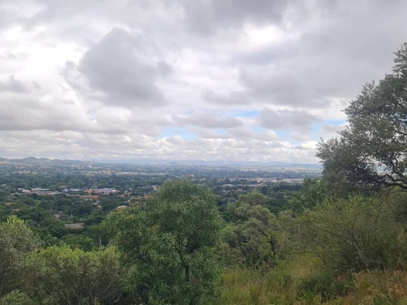 A scenic elevated view overlooking the surrounding landscape and residential area, showcasing the natural topography and greenery of the property location.