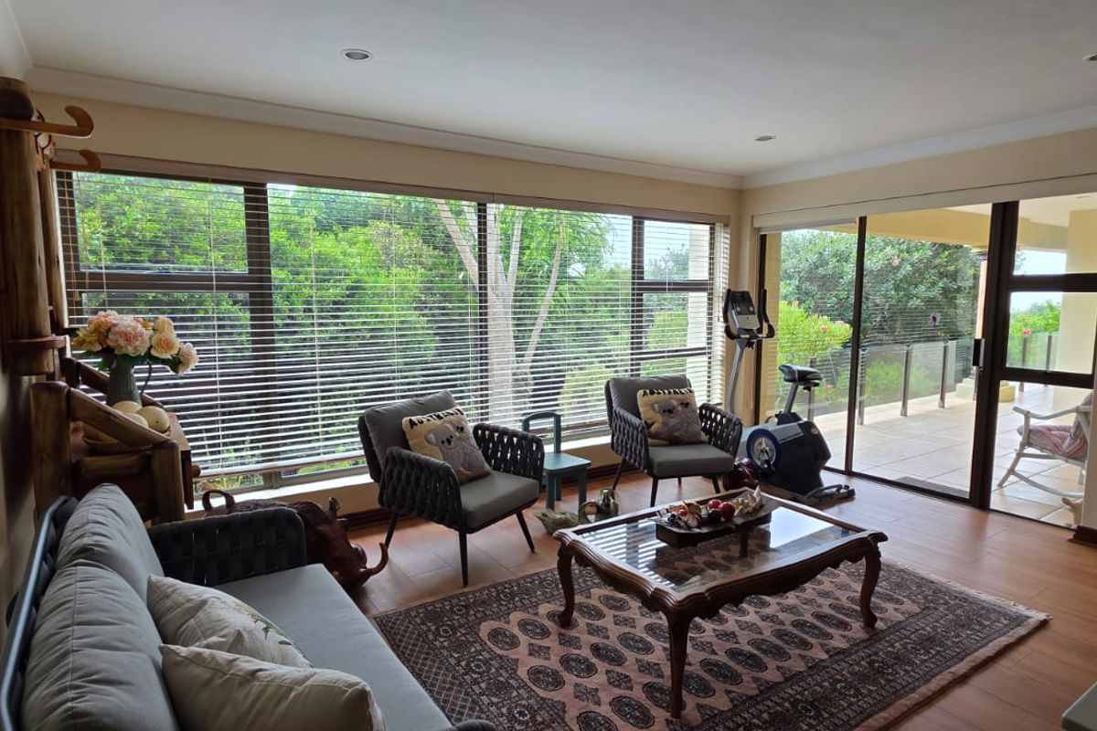 Bright living room featuring large windows and sliding glass doors that provide ample natural light and access to the outdoor patio area.