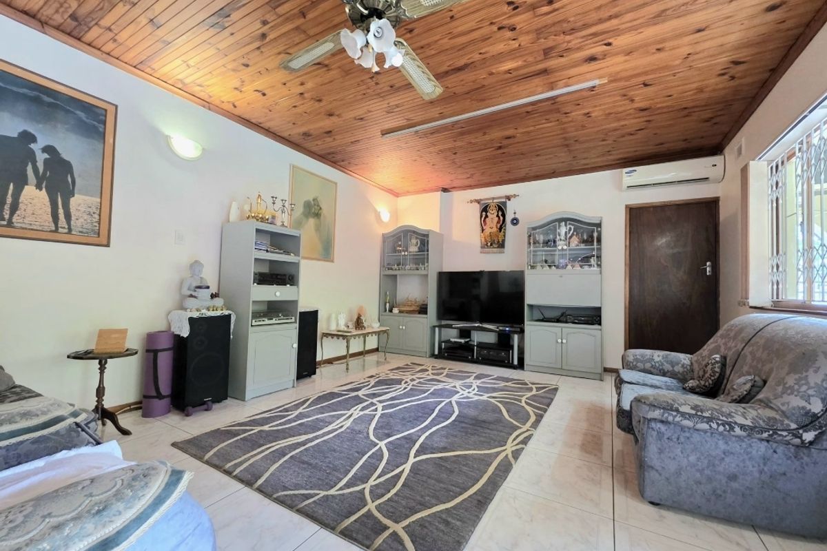 A living room featuring a timber tongue and groove ceiling, ceiling fan, split system air conditioner, and tiled flooring.