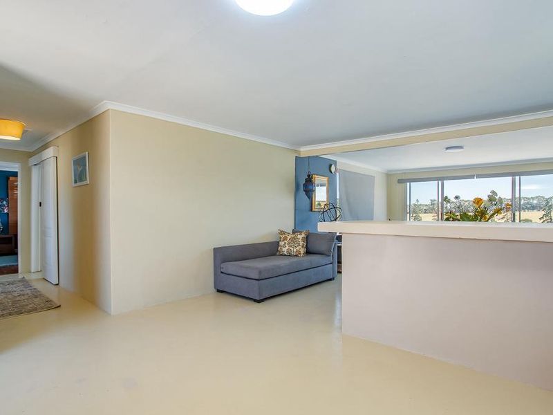 Open plan living area featuring a breakfast bar, neutral wall finishes, and large sliding glass doors providing natural light and scenic views.