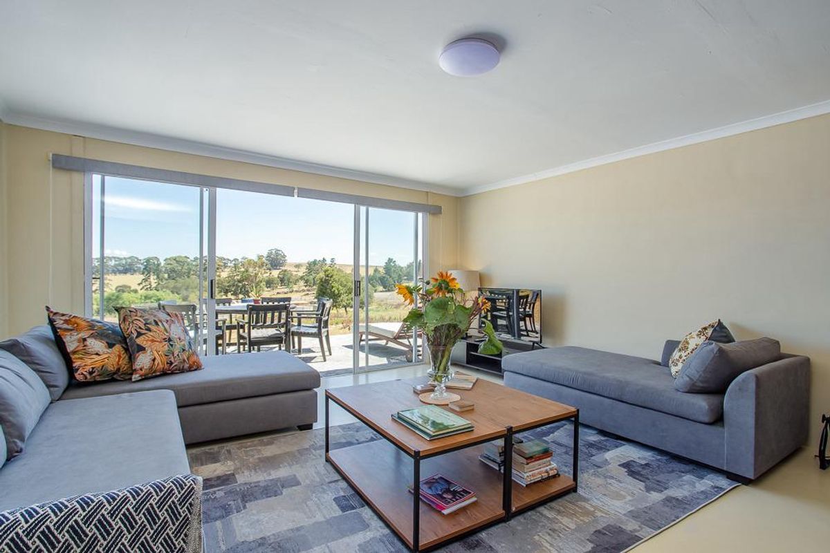 A bright living room featuring large sliding glass doors that provide natural light and access to an outdoor patio area with scenic views.