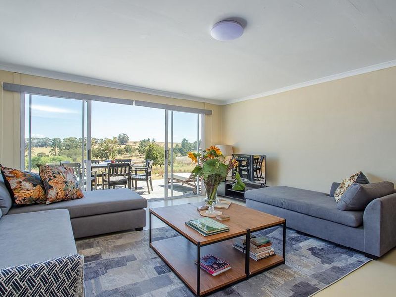 A bright living room featuring large sliding glass doors that provide natural light and access to an outdoor patio area with scenic views.