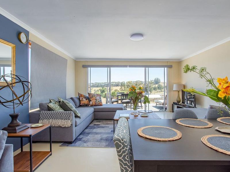 Spacious open-plan living and dining area featuring large sliding glass doors that provide natural light and access to the outdoor patio.