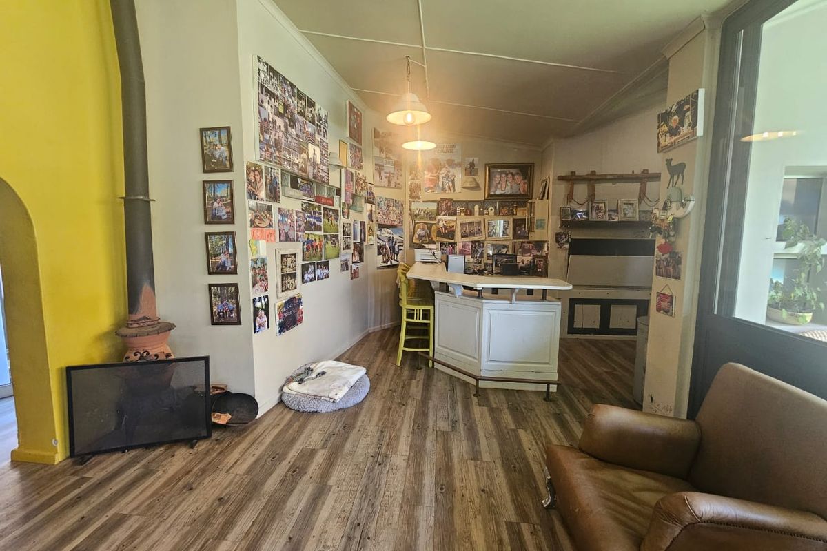 A rustic living area featuring a built-in bar counter and a traditional wood-burning fireplace, finished with wood-look laminate flooring.