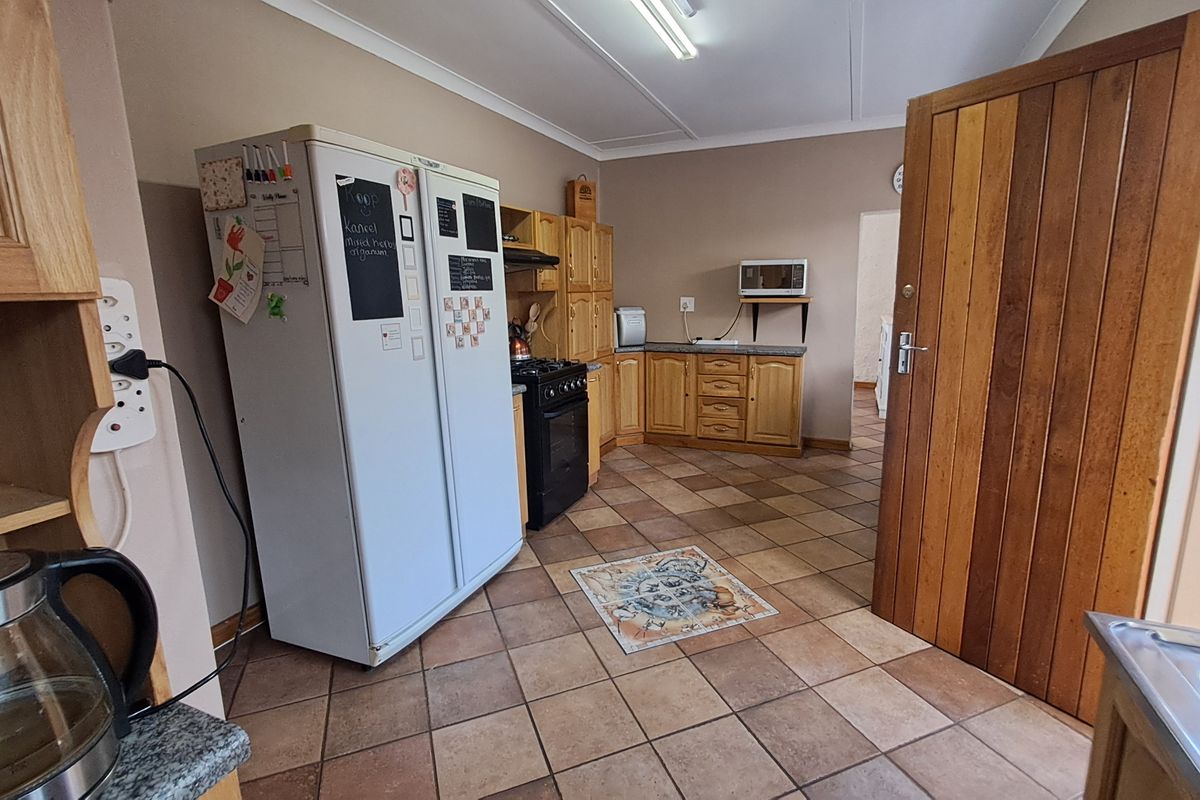A functional kitchen featuring wooden cabinetry, tiled flooring, and a gas stove with an integrated oven.