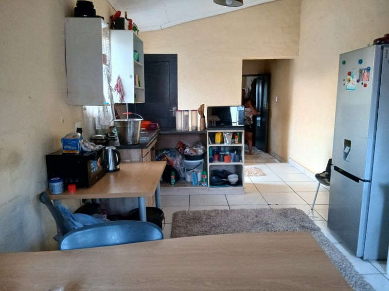 A functional kitchen area featuring tiled flooring and basic built-in cabinetry, offering a practical layout with potential for cosmetic updates.