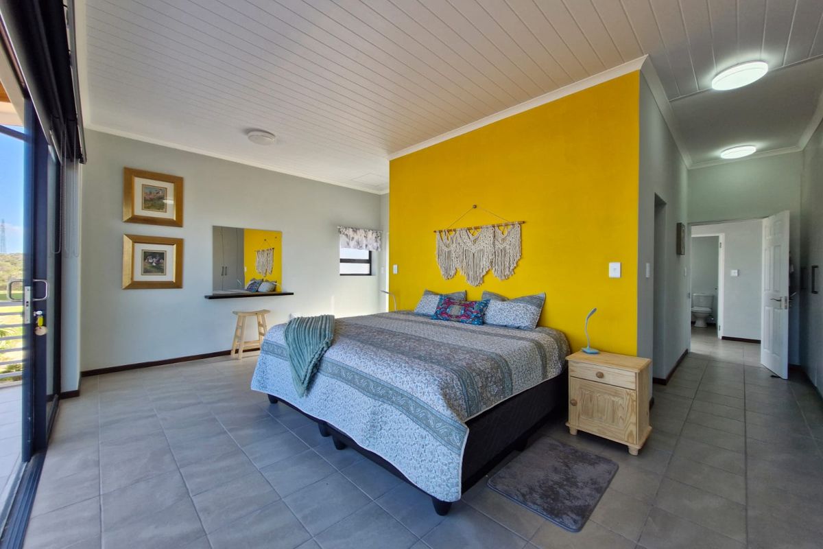 Spacious bedroom featuring tiled flooring, a tongue and groove ceiling, and a large sliding glass door providing access to the outdoors.