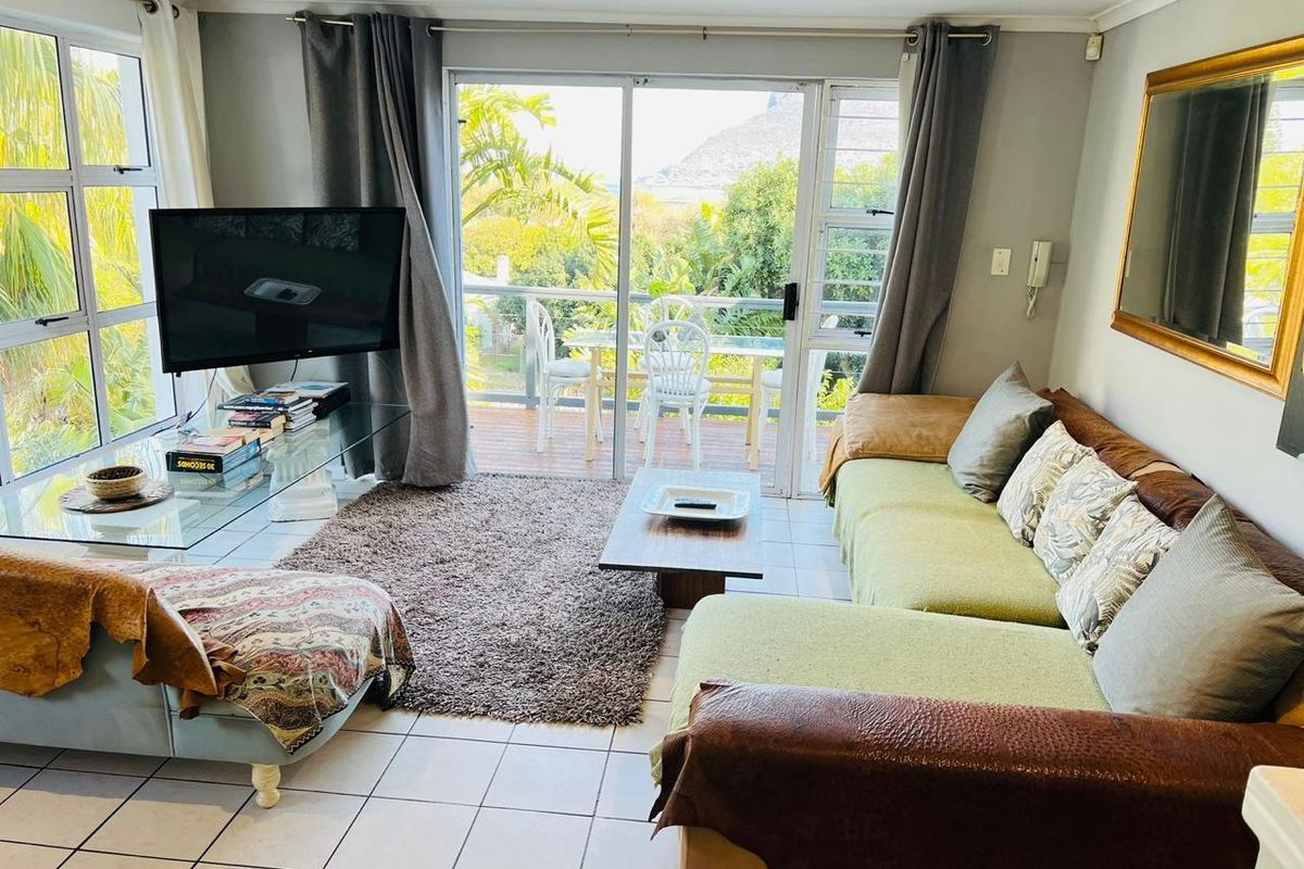 Bright living room featuring large sliding glass doors that open onto a private balcony with scenic views.