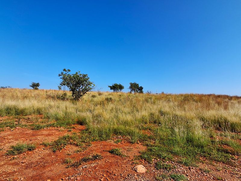 A view of the vacant residential land featuring natural grass and soil, ready for development.