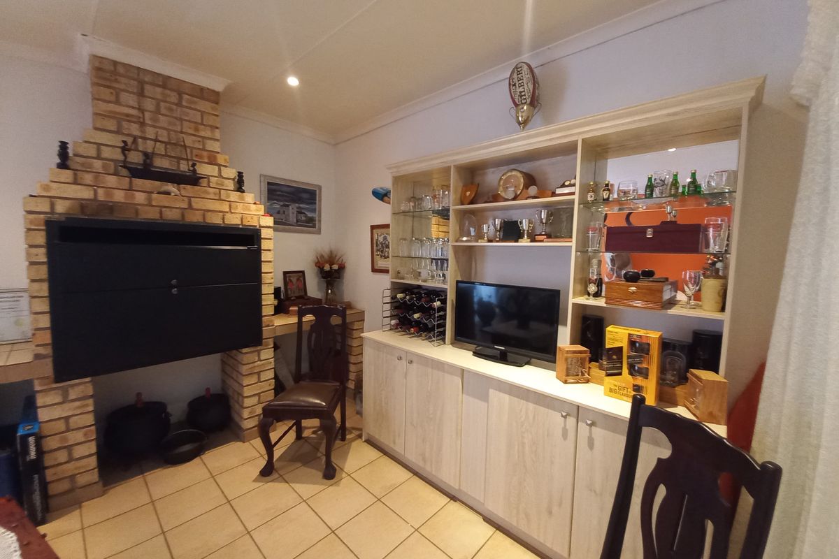Living area featuring a prominent brick fireplace and extensive built-in cabinetry with integrated shelving and storage.