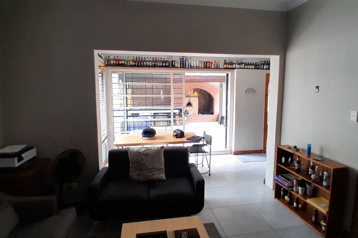 A living room featuring tiled flooring and a large sliding glass door that provides direct access to an outdoor patio area.