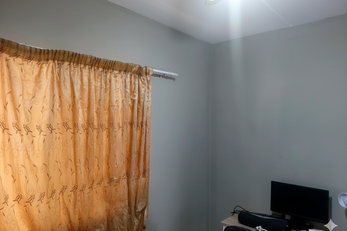 A simple bedroom interior featuring neutral wall paint, a curtain rod, and a ceiling light fixture.