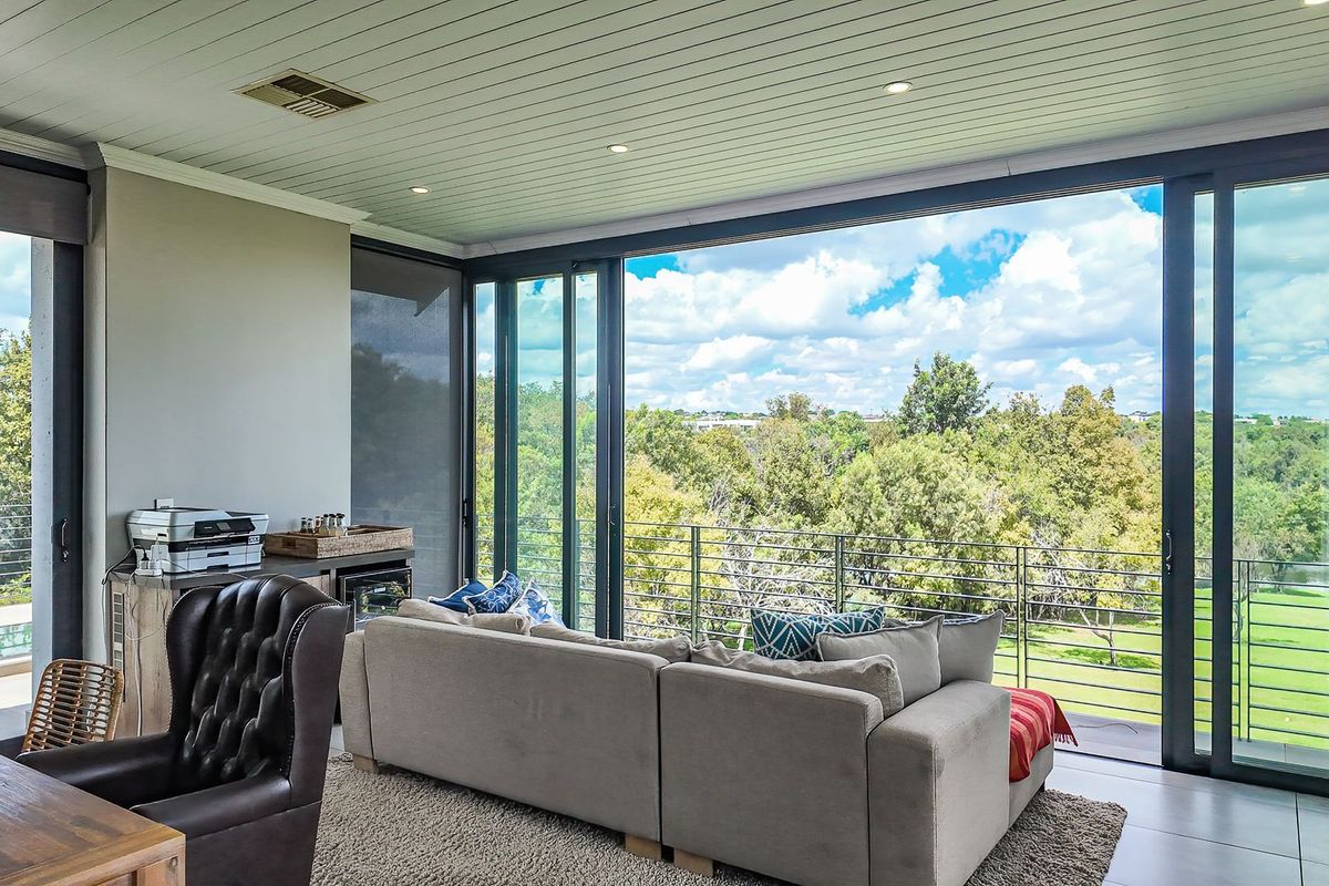 Spacious living area featuring large sliding glass doors that open to a balcony with scenic views, complemented by recessed lighting and modern finishes.