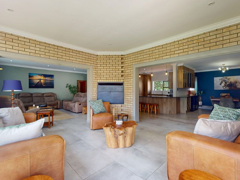 Spacious open-plan living area featuring exposed brick walls, a built-in fireplace, and seamless flow into the kitchen and dining spaces.