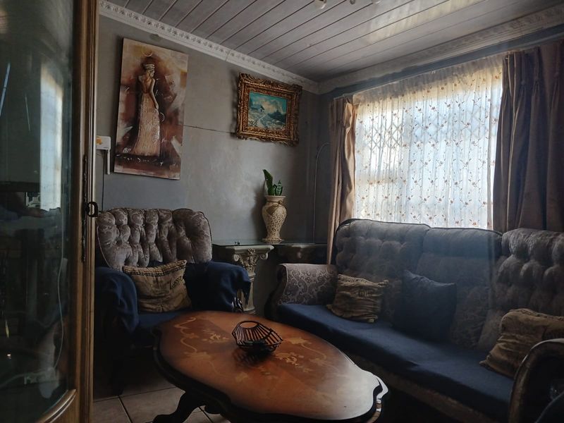 A living room featuring tiled floors, a tongue and groove ceiling with crown molding, and a security gate on the window.