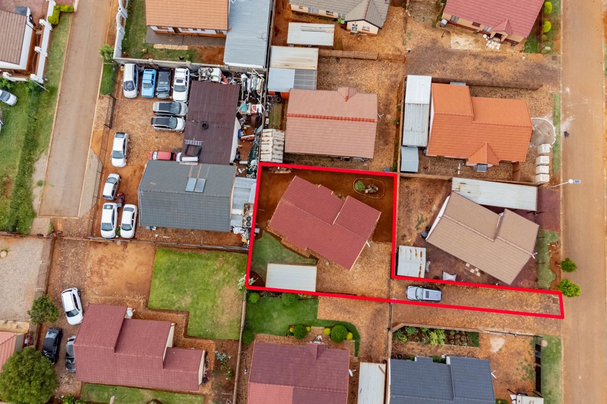 Aerial view of a residential property highlighting the roof structure, plot boundaries, and surrounding neighborhood layout.