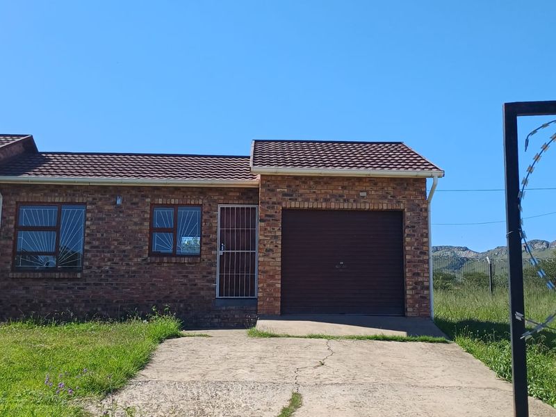 Front elevation of a face brick house featuring a single garage, concrete driveway, and security features on windows and doors.