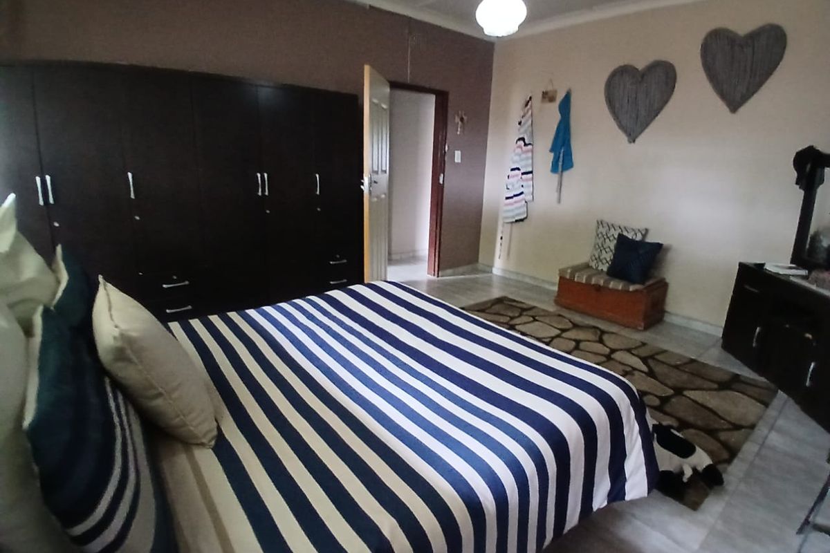 A bedroom featuring tiled flooring, a large built-in wardrobe, and coved ceiling details.