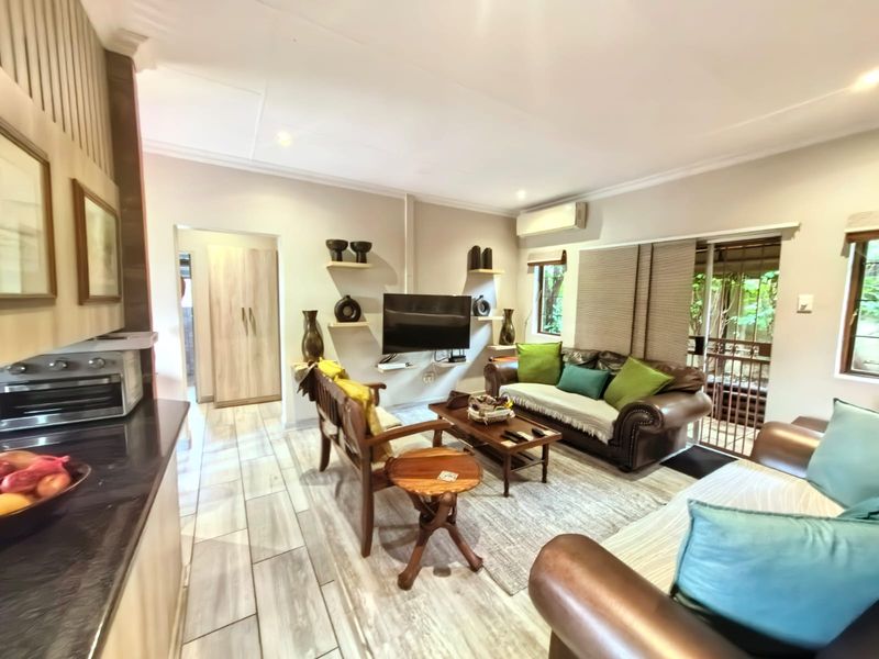 Open-plan living area featuring tiled flooring, split-system air conditioning, and direct access to an outdoor space through a sliding glass door.