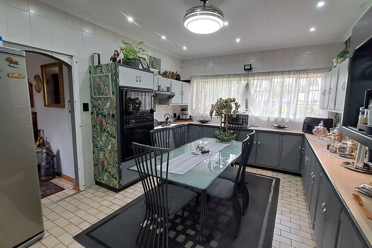 A functional kitchen featuring tiled flooring, built-in cabinetry, a built-in oven, and an extractor fan, offering a practical layout for daily meal preparation.