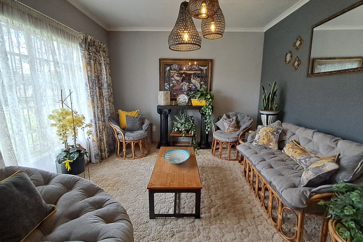 A cozy living room featuring neutral wall tones, a dark accent wall, and decorative pendant lighting, creating a warm and inviting atmosphere.