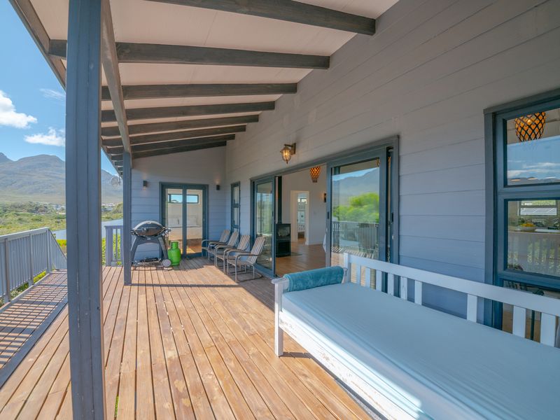 Spacious covered timber deck featuring sliding glass doors, mountain views, and a well-maintained outdoor living area.