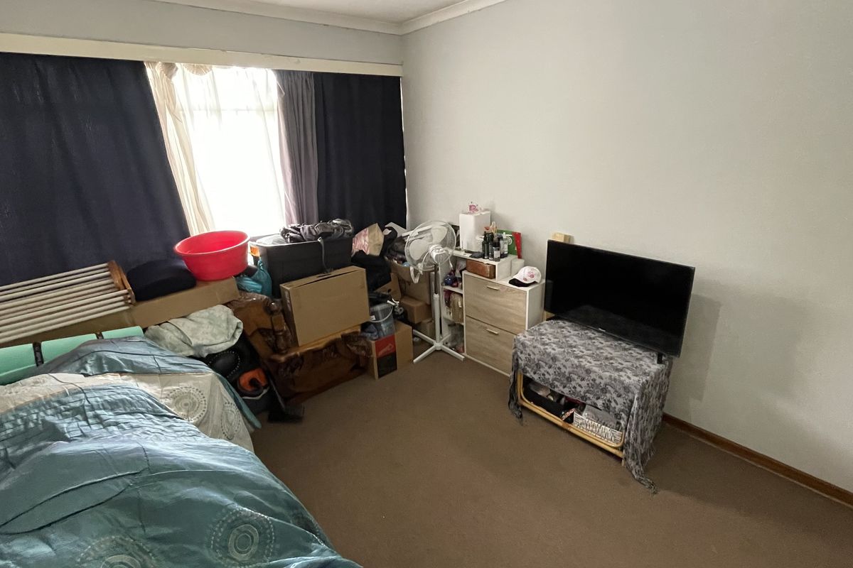 A bedroom featuring carpet flooring and coving, currently used for storage.