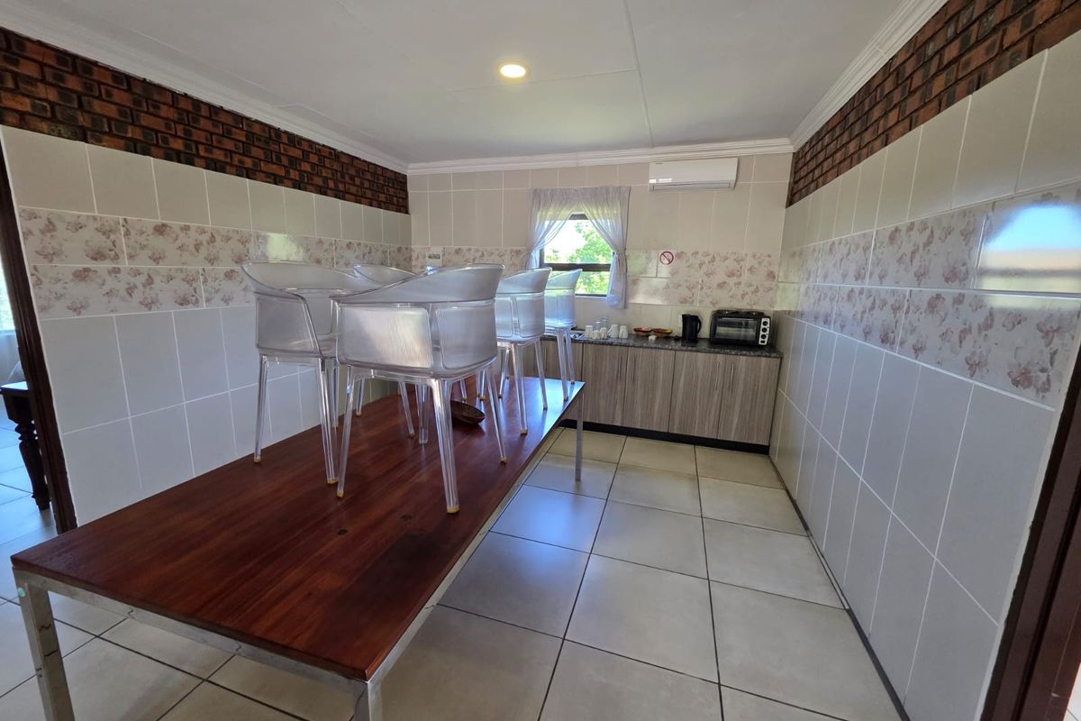 A functional kitchen area featuring tiled walls, built-in cabinetry, and a split-system air conditioning unit.