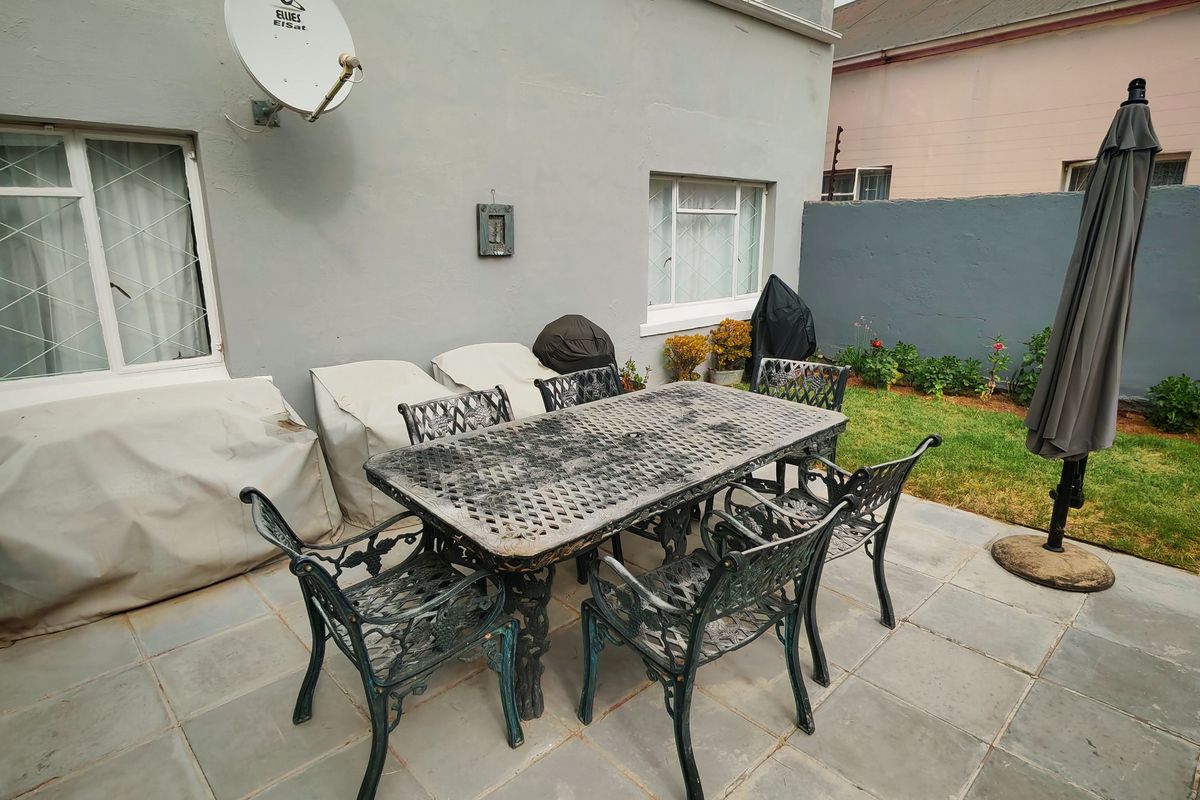 A paved outdoor patio area featuring a rear garden space, ideal for alfresco dining and outdoor relaxation.