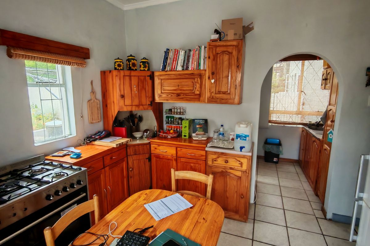 A functional kitchen featuring wooden cabinetry, a gas stove, and an arched doorway leading to a secondary prep or scullery area.
