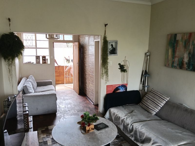 Open plan living area featuring parquet flooring and direct access to an outdoor balcony through a security gate.