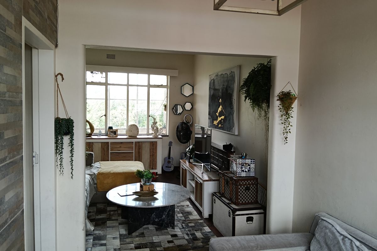 A cozy living room featuring a large multi-pane window, built-in cabinetry, and a central ceiling light fixture.