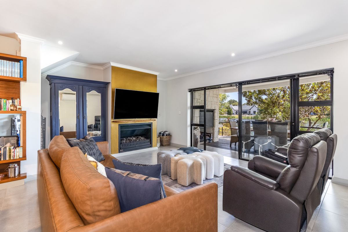 Spacious living room featuring a built-in fireplace with a gold accent wall and large sliding glass doors opening to a covered patio.