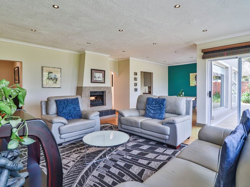 Spacious living room featuring a built-in fireplace, recessed downlighting, and large sliding glass doors providing direct access to the outdoor patio area.