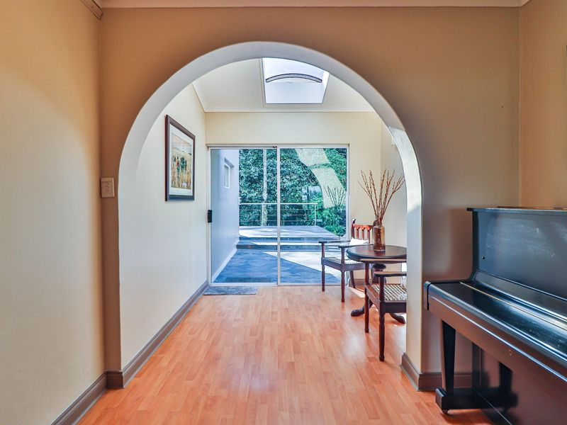 Welcoming entry area featuring a distinctive architectural archway, a bright skylight, and sliding glass doors providing direct access to the outdoor patio.