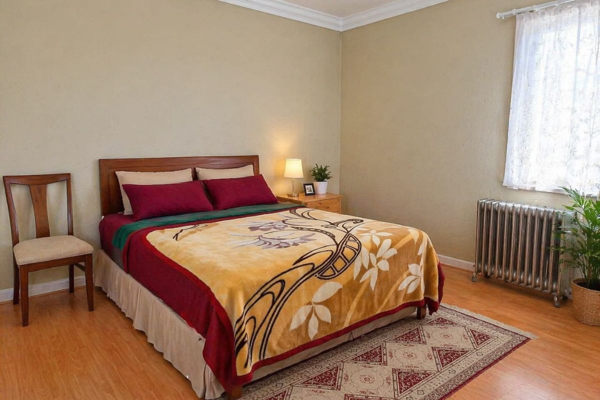 A bedroom featuring laminate flooring, crown molding, and a built-in radiator heating system.