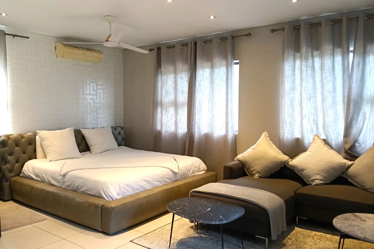 Spacious bedroom featuring tiled flooring, recessed downlighting, a ceiling fan, and a wall-mounted air conditioning unit.