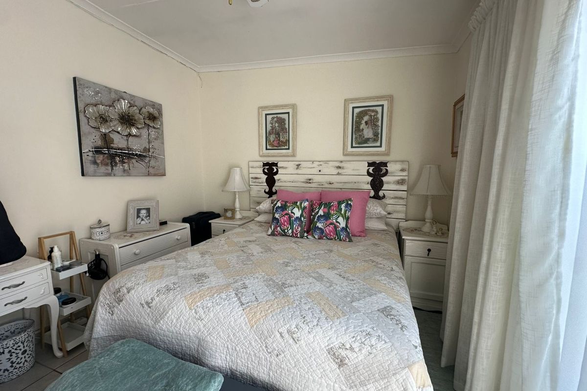 A cozy bedroom featuring a built-in ceiling fan and neutral wall finishes, providing a comfortable and functional sleeping space.