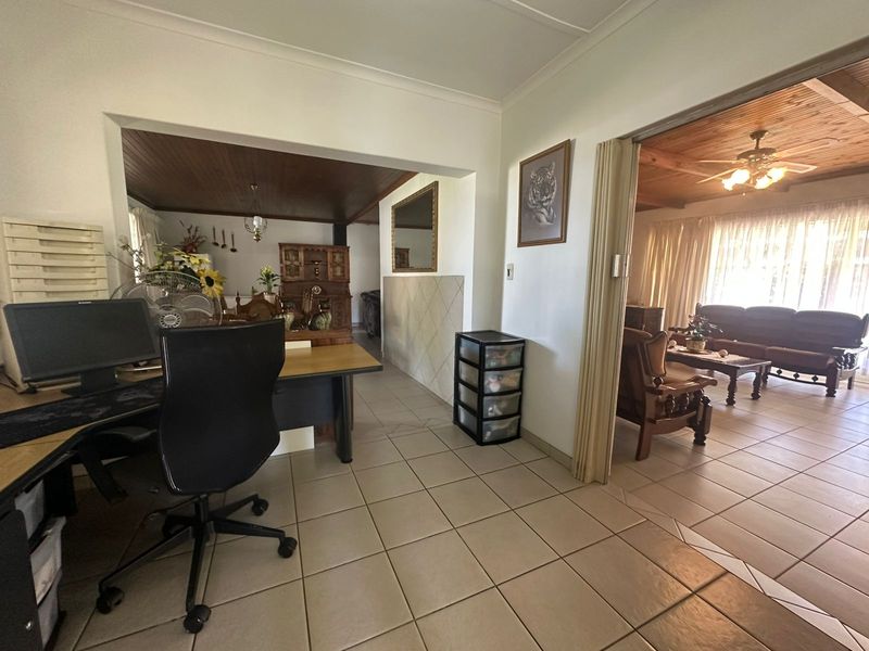 Open plan living area featuring ceramic floor tiles and a timber tongue and groove ceiling with an integrated ceiling fan.