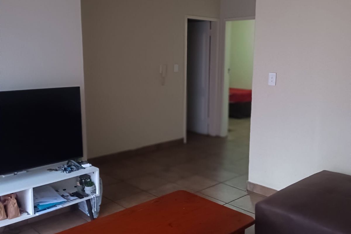 A living room area featuring tiled flooring and recessed downlights, providing a neutral base for interior design.