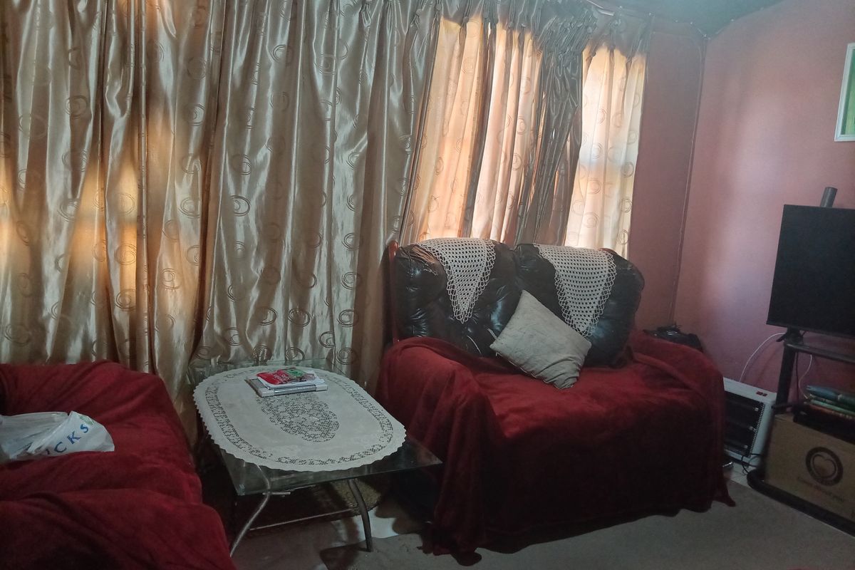 A living room area featuring floor-to-ceiling curtains and standard wall finishes, requiring cosmetic updates to improve the overall aesthetic and appeal.