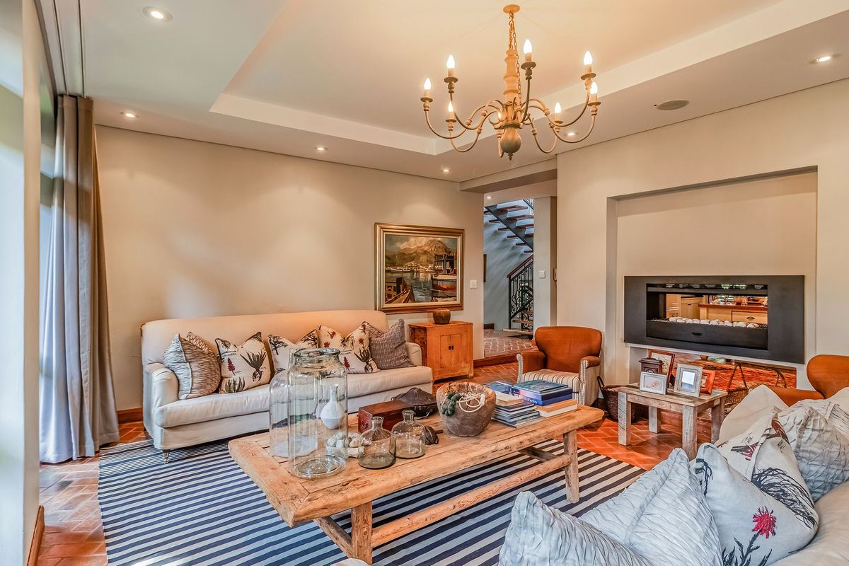 Spacious living room featuring a built-in fireplace, recessed ceiling detail, and terracotta tiled flooring, creating a warm and inviting atmosphere.