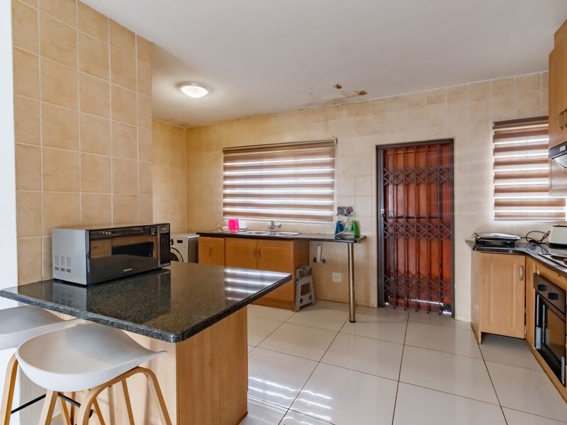 A functional kitchen featuring granite countertops, built-in cabinetry, and tiled finishes, requiring minor ceiling repairs.