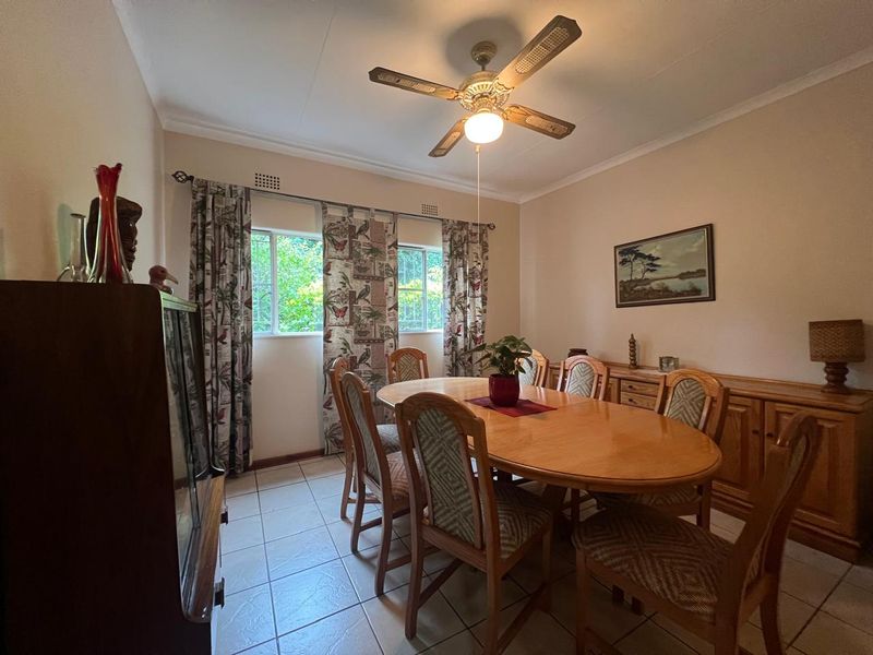 A dining room featuring tiled flooring, a ceiling fan, and built-in cabinetry, providing a functional space for family meals.