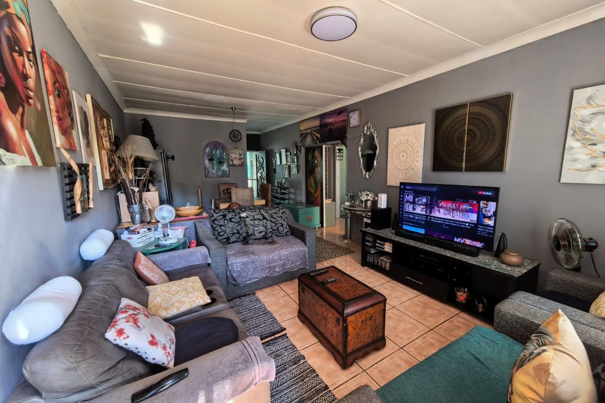 A living room featuring tiled flooring and a neutral wall finish, providing a functional space for relaxation and entertainment.