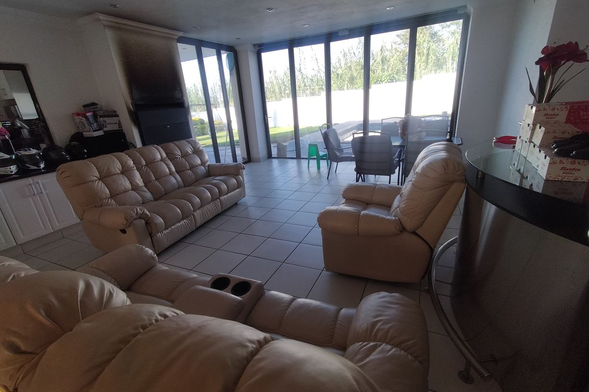 Spacious living room featuring tiled flooring, a built-in fireplace with visible smoke staining, and large sliding glass doors providing access to the outdoor area.