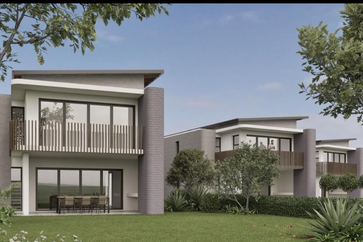 A modern townhouse development featuring rear balconies, covered patios, and landscaped garden areas with contemporary architectural design.